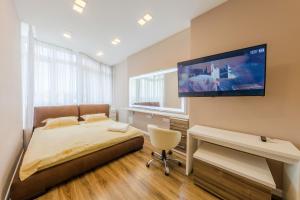 um quarto com uma cama e uma televisão de ecrã plano na parede em Квартири подобово біля вокзалу em Kiev