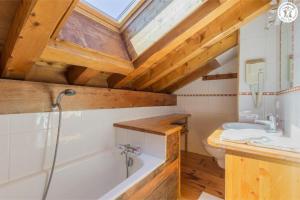a bathroom with a white tub and a sink at Chalet Duhoux in Les Allues