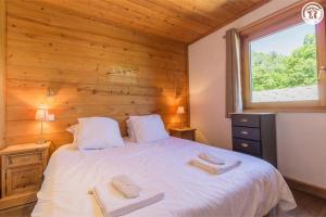 a bedroom with a bed with two towels on it at Chalet Duhoux in Les Allues