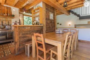 a dining room with a wooden table and chairs at Chalet Duhoux in Les Allues