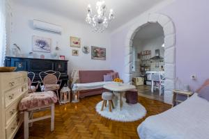 a living room with a bed and a table and a couch at Holiday Home Inga with free private parking in Rijeka