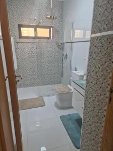 a small bathroom with a toilet and a shower at SUITES-HOME, CIDADELA in Praia