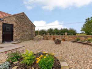 a garden with a stone building and a stone wall at 2 bed property in Hornsea 85723 in Hornsea