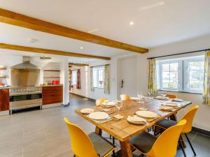 a dining room with a large wooden table and yellow chairs at 3 Bed in Caldbeck 86087 in Caldbeck