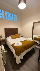 1 dormitorio con 1 cama grande y espejo en Casa Arte Nova do Rossio, en Aveiro