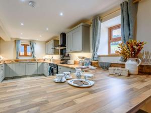 a large kitchen with wooden floors and white cabinets at 4 Bed in Llandrindod Wells 86118 in Llanbadarn-fynydd