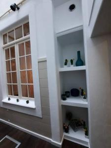 Habitación con estanterías blancas y ventana en Casa Arte Nova do Rossio, en Aveiro