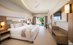 Riu Palace Aquarelle - All Inclusive في فالماوث: غرفة نوم بسرير ابيض كبير وتلفزيون