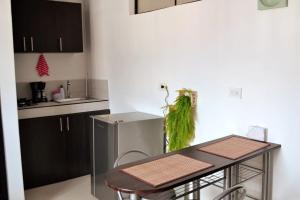 a kitchen with a table with a green item on the wall at GURUS FR | Cómodo Edificio Casa Confort en Providencia in Pereira