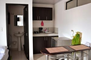 a small kitchen with a table and a sink at GURUS FR | Cómodo Edificio Casa Confort en Providencia in Pereira