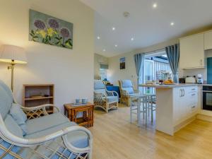 a kitchen and living room with chairs and a table at 1 bed property in Sherborne 86426 in South Cadbury