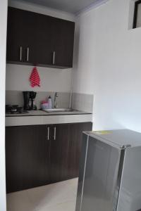 a kitchen with black cabinets and a sink at GURUS FR | Cómodo Edificio Casa Confort en Providencia in Pereira