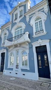 un edificio azul con adornos blancos en una calle en Casa Arte Nova do Rossio, en Aveiro