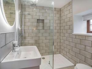 ein weißes Bad mit einem Waschbecken und einer Dusche in der Unterkunft 3 bed in Llandysul 87071 in Pencader