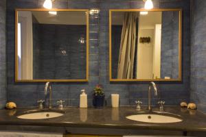 a bathroom with two sinks and two mirrors at Dimora Dei Giganti in Naples