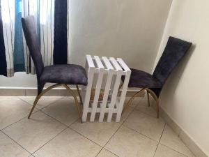 2 sillas y una mesa en una habitación en Cozy Nyumbani Studio Apartment In Mtwapa ., en Mtwapa