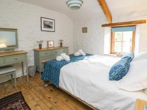 a bedroom with a bed and a desk and a television at Ty Len in Haverfordwest