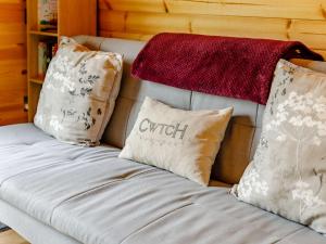 a couch with pillows and a red blanket on it at 1 Bed in Llandrindod Wells 88204 in Llandegley