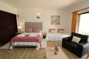 een hotelkamer met 2 bedden en een bank bij Camélia 89 São Rafael - Albufeira, Algarve in Albufeira