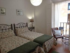 1 dormitorio con 1 cama, 1 silla y 1 ventana en Alojamiento Oviedo 1, en Oviedo
