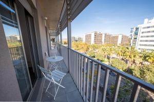 a balcony with a chair and a view of a city at Chic City Haven: Modern Apartment in Castellón in Castellón de la Plana