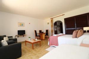 een hotelkamer met 2 bedden en een televisie bij Camélia 89 São Rafael - Albufeira, Algarve in Albufeira