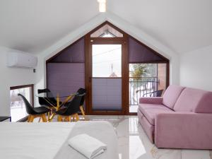 a living room with a purple couch and a table at EdelHouse in Szczawnica