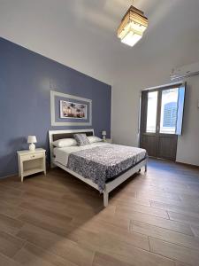 um quarto com uma cama e uma parede azul em Luna Blu Apartment em Palermo