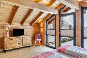 a bedroom with a bed and a tv on a wooden wall at Chalet Aus Holz in Garmisch-Partenkirchen