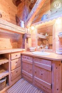 baño con lavabo en una cabaña de madera en Chalet de Marie proche des Saisies en Queige