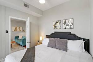 a bedroom with a white bed and a blue chair at 2BR Bright and Lovely Apt - Leland 3 in Chicago