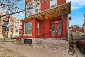 a red building with a red door on a street at 2BR Bright and Lovely Apt - Leland 3 in Chicago
