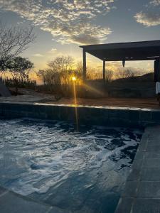 una piscina con puesta de sol en el fondo en Casa ecológica Toca do Barreiro, en Coronel José Diaz