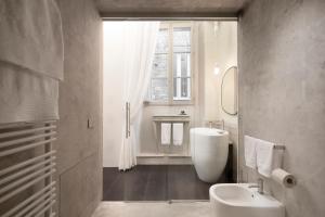 La salle de bains est pourvue d'un lavabo, de toilettes et d'une fenêtre. dans l'établissement Palazzo Giusti Suites and Spa, à Urbino