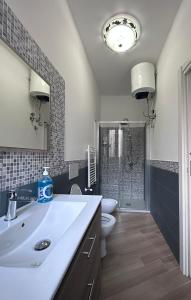 uma casa de banho com um lavatório, um WC e um espelho. em Luna Blu Apartment em Palermo