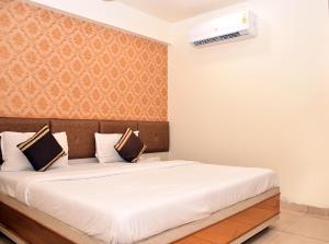 una camera da letto con un grande letto e un copriletto bianco di Hotel Bharosa inn Naroda a Ahmedabad