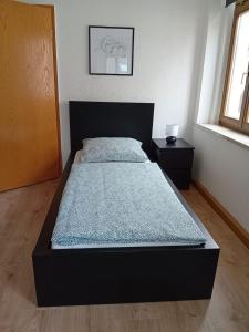 a bed in a bedroom with a black bed frame at Zentral und ruhig in Auerbach in Auerbach