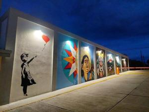 un mur avec une fresque murale représentant une femme tenant un ballon dans l'établissement Hotel PZ Country Club & Conference Center, à San Isidro de El General