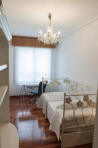 ア・コルーニャにあるSakura Homes Torre de Hércules 4 plazasのベッドとシャンデリアのある寝室