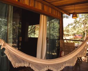 a hammock hanging on a screened in porch at Baguá Bangalôs in Alto Paraíso de Goiás