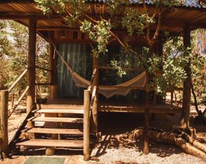 a hammock in front of a tree house at Baguá Bangalôs in Alto Paraíso de Goiás