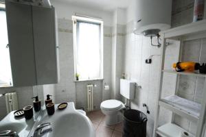 bagno con lavandino, servizi igienici e finestra di Casa Verena ad Aosta