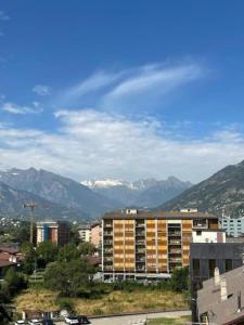 eine Stadt mit einem Gebäude und Bergen im Hintergrund in der Unterkunft Casa Verena in Aosta