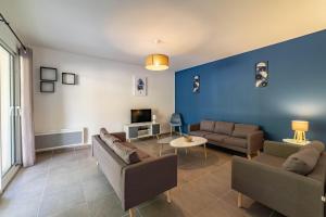 ein Wohnzimmer mit 2 Sofas und einer blauen Wand in der Unterkunft Gite Les Bouches Rouges in Vesseaux