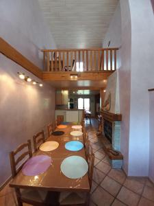uma sala de jantar com uma mesa longa e uma escada em Gîte le Chamoyard em Chamoux-sur-Gelon