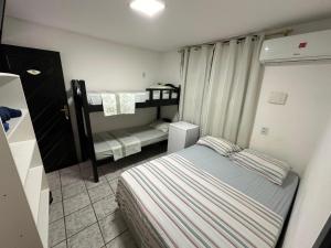 a small bedroom with two bunk beds in it at Pousada Dunas Natal in Natal