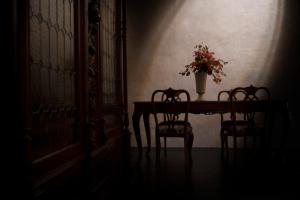 a table with a vase of flowers and two chairs at Palazzo Giusti Suites and Spa in Urbino