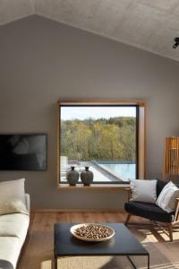 a living room with a couch and a large window at Villa Ulmus near Motovun for 6 people with heated pool & jacuzzi in Karojba