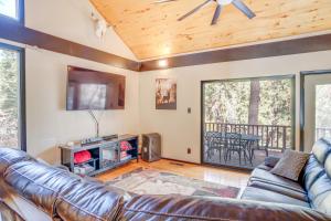 a living room with a leather couch and a television at Ruidoso Cabin Retreat with Multi-Level Deck in Ruidoso