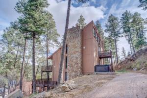 a house on the side of a hill with trees at Ruidoso Cabin Retreat with Multi-Level Deck in Ruidoso